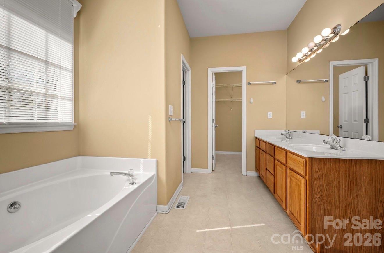 523 Shepherds Creek Circle Rutherfordton, NC 28139 - Photo 24 of 31 a bathroom with a granite countertop tub a double vanity sink and a large mirror