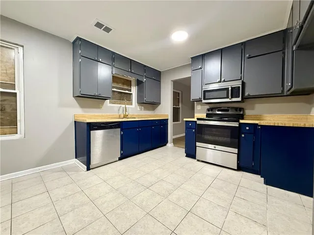 a kitchen with stainless steel appliances a stove a sink and a refrigerator