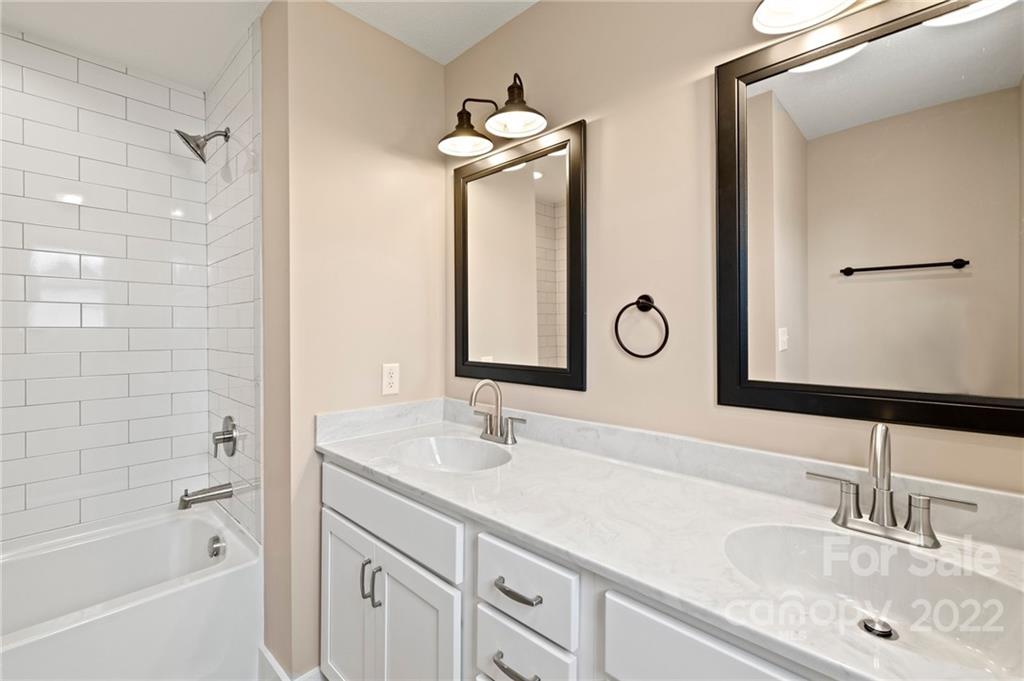 53 Sharptown Road Canton, NC 28716 - Photo 23 of 34 a bathroom with a granite countertop sink a mirror and a shower
