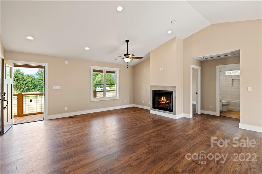 53 Sharptown Road Canton, NC 28716 - Photo 5 of 34 an empty room with wooden floor a fireplace and windows