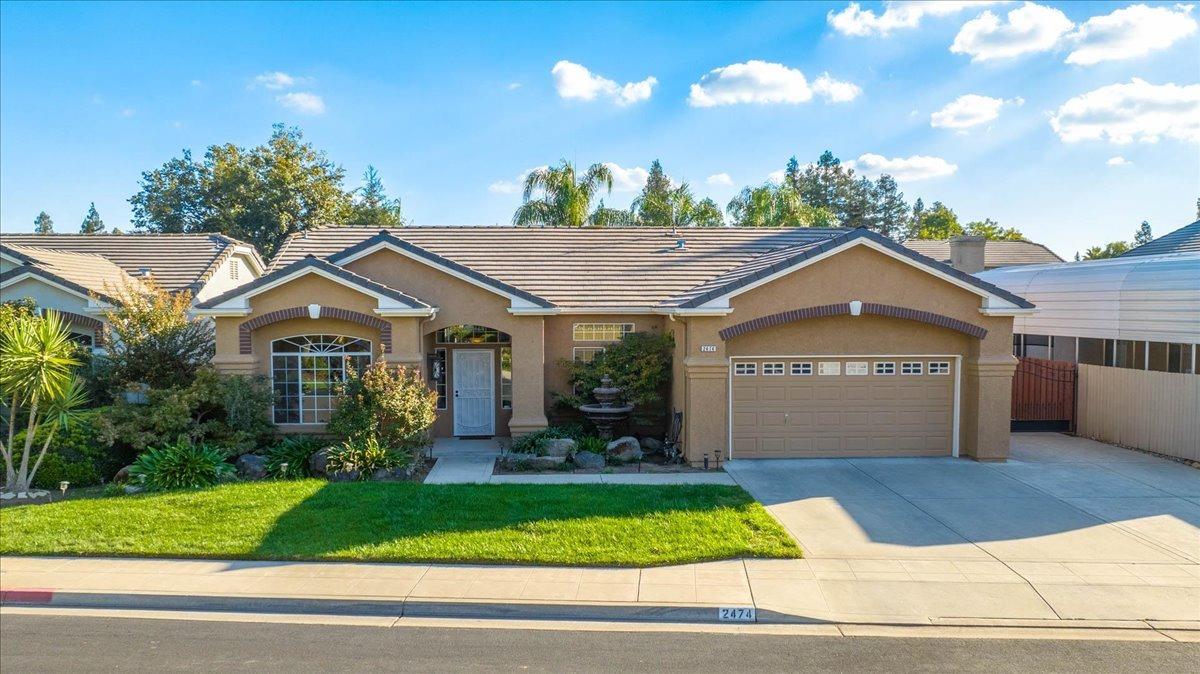 a view of a house with a yard and potted plants