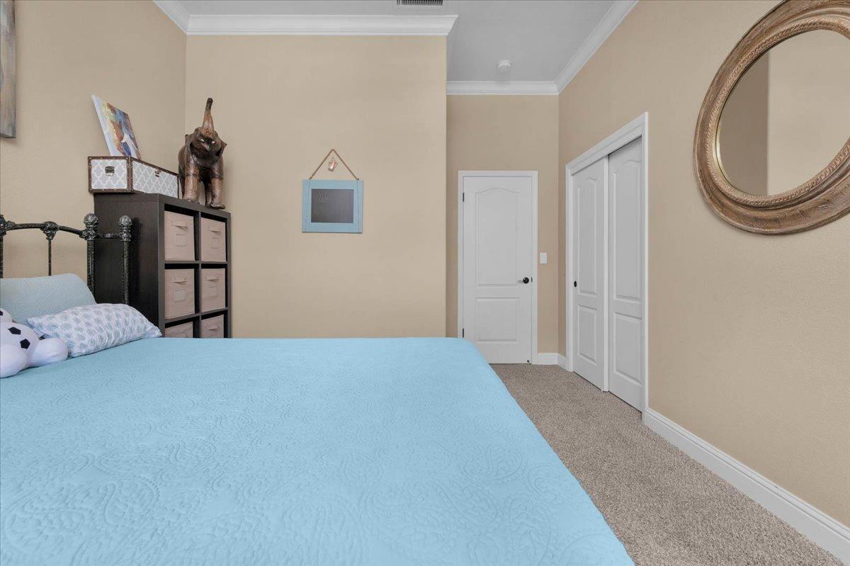 2474 Twain Avenue Clovis, CA 93611 - Photo 17 of 55 a bedroom with a bed and a chandelier