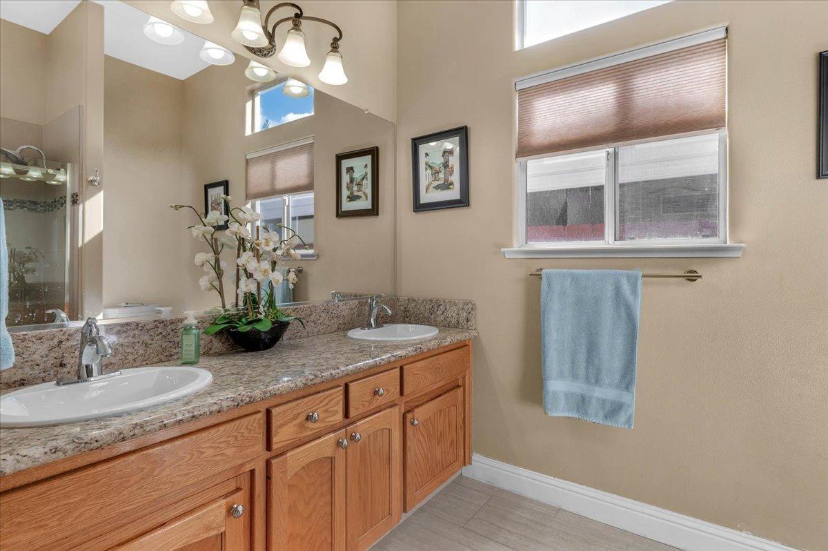 2474 Twain Avenue Clovis, CA 93611 - Photo 20 of 55 a bathroom with a granite countertop double vanity and a mirror