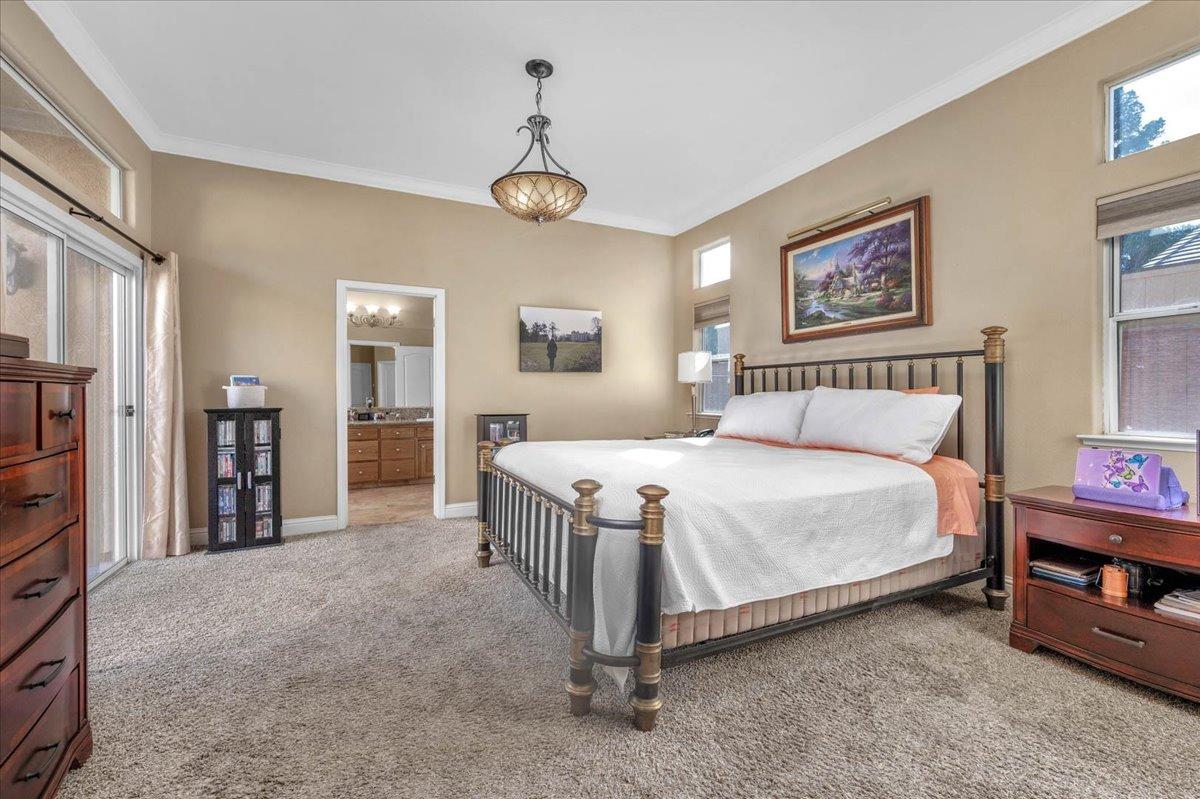 2474 Twain Avenue Clovis, CA 93611 - Photo 23 of 55 a bedroom with a bed and a chandelier