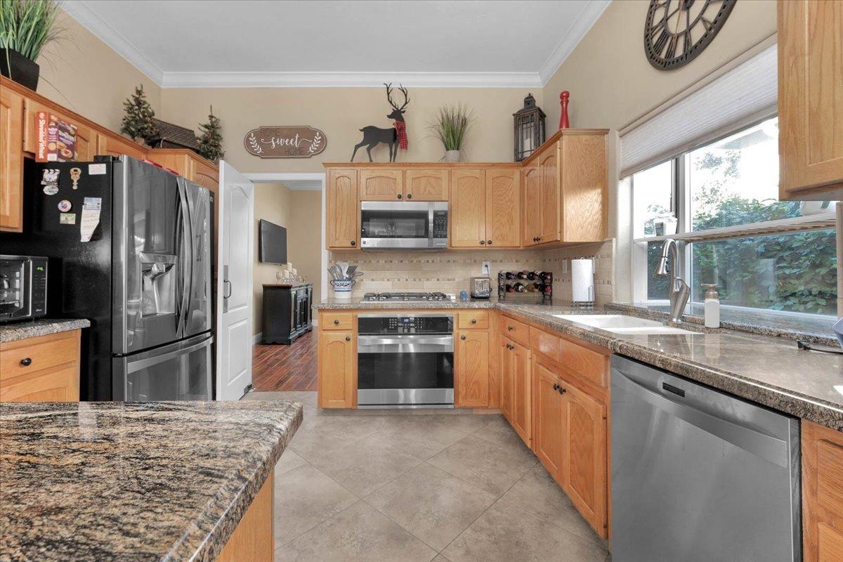 2474 Twain Avenue Clovis, CA 93611 - Photo 5 of 55 a kitchen with stainless steel appliances granite countertop a sink stove and refrigerator