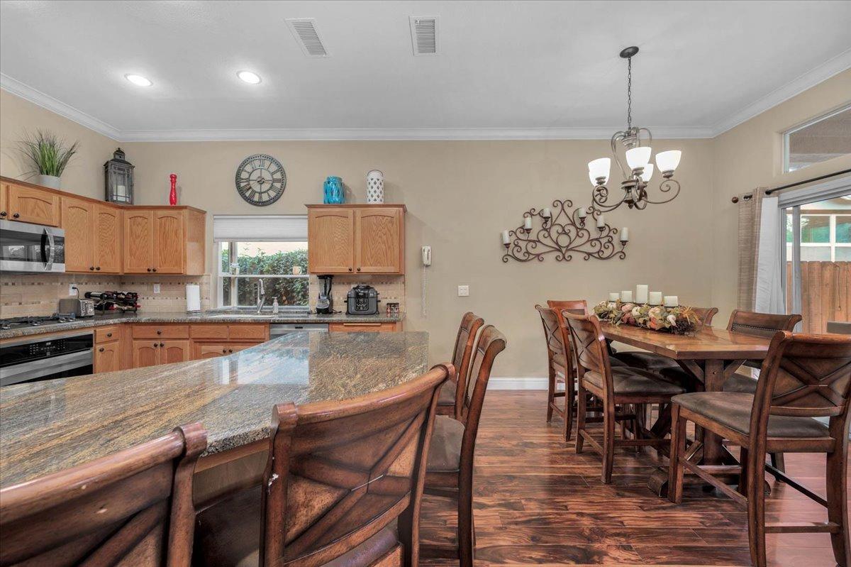 2474 Twain Avenue Clovis, CA 93611 - Photo 9 of 55 a dining area with granite countertop a dining table chairs and kitchen view