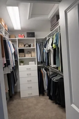 a view of walk in closet with clothes and shoes