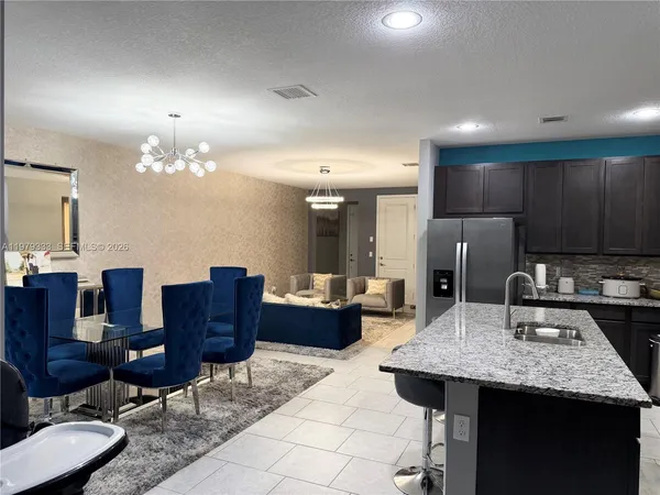 a kitchen with a table chairs and refrigerator