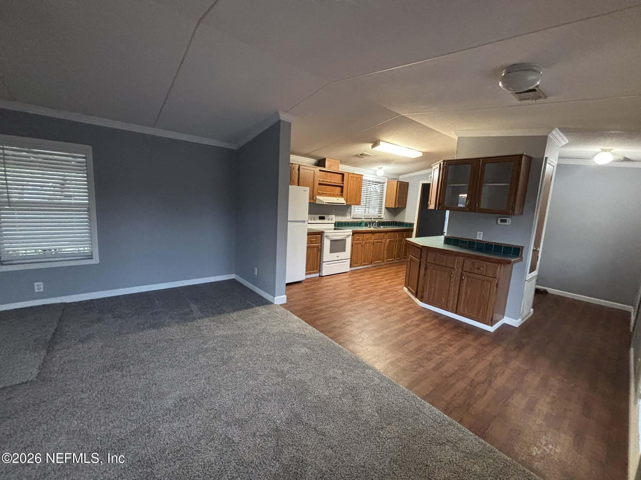 7624 Southwest County Road 225 Starke, FL 32091 - Photo 13 of 56 a kitchen with stainless steel appliances granite countertop a refrigerator and a stove top oven