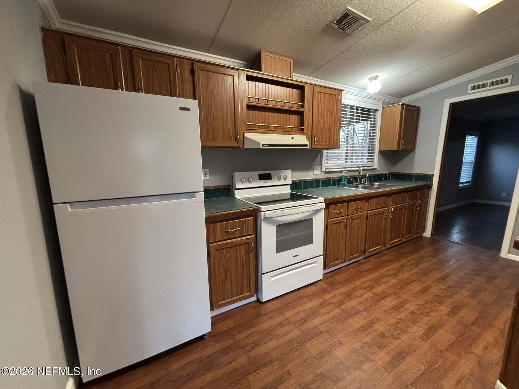 7624 Southwest County Road 225 Starke, FL 32091 - Photo 15 of 56 a kitchen with stainless steel appliances granite countertop a refrigerator a stove a sink and a microwave
