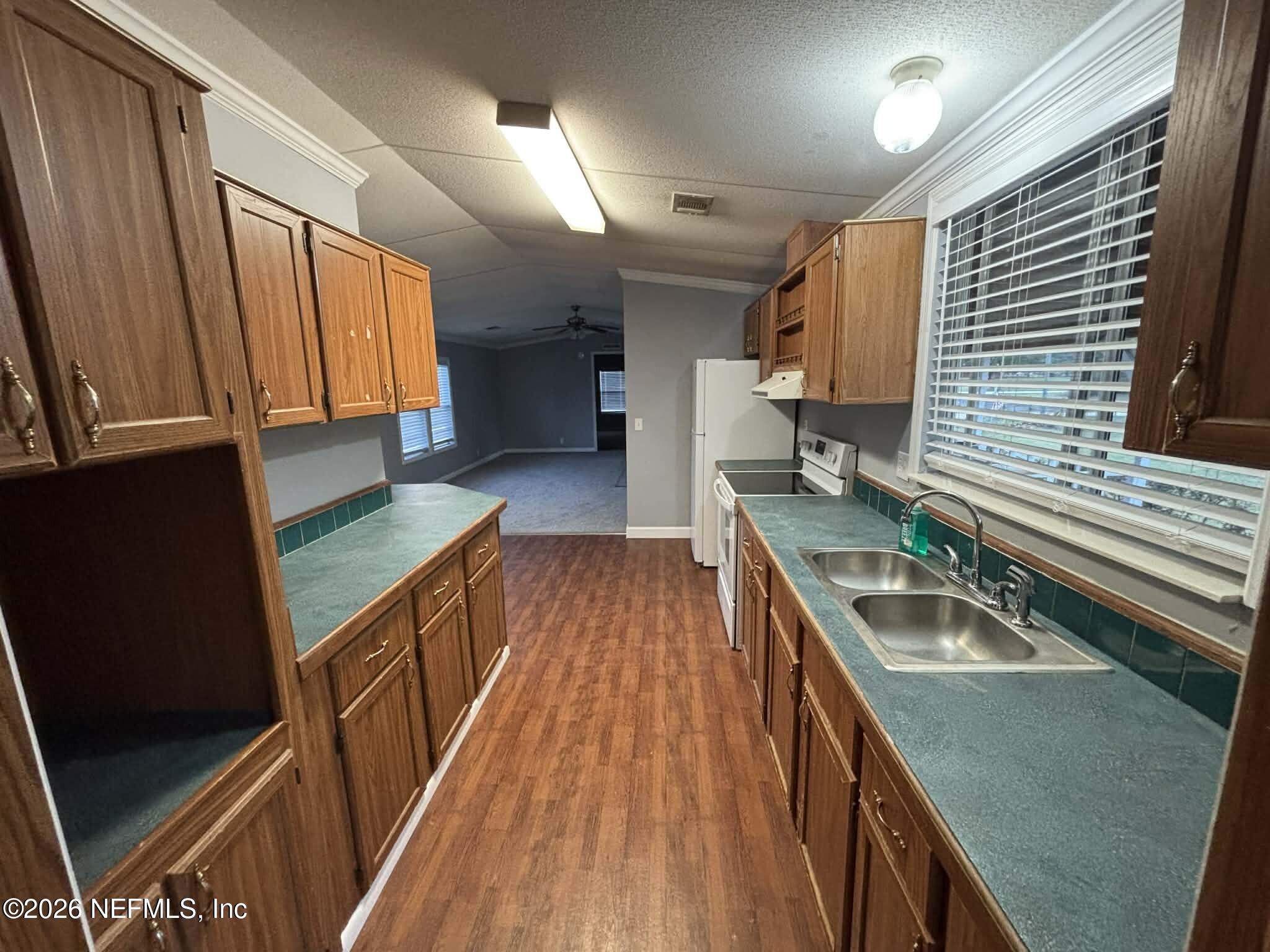 7624 Southwest County Road 225 Starke, FL 32091 - Photo 18 of 56 a kitchen with a sink a counter top space stainless steel appliances a window and a counter space
