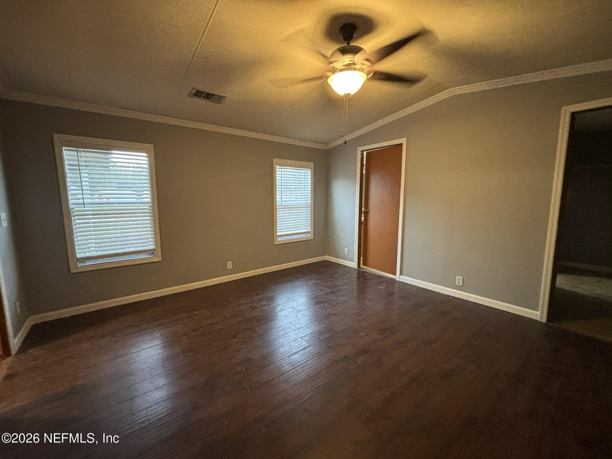 7624 Southwest County Road 225 Starke, FL 32091 - Photo 22 of 56 an empty room with wooden floor fan and windows