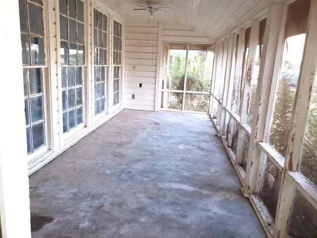 a view of an empty room with wooden floor and windows