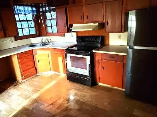 a kitchen with stainless steel appliances granite countertop a refrigerator a stove and a sink