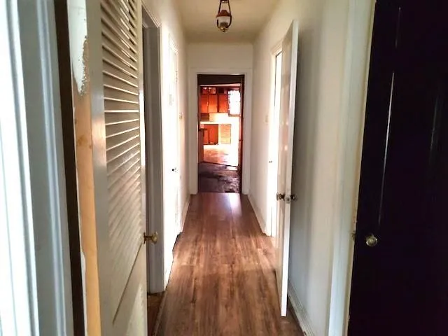 a view of a hallway with wooden floor and stairs