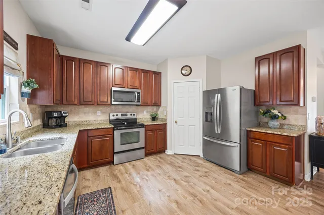 a kitchen with granite countertop stainless steel appliances and wooden cabinets
