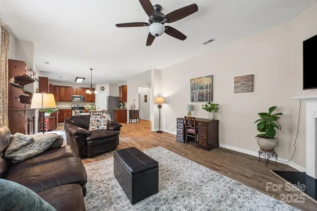 a living room with furniture kitchen view and a potted plant