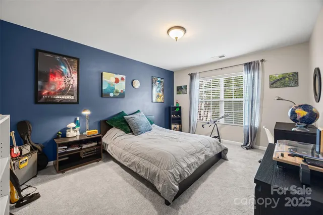 a bedroom with a bed a couch and a window