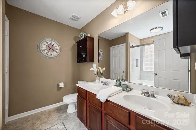 a bathroom with a sink a toilet and a mirror