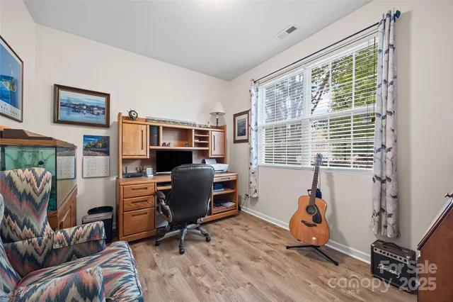 a view of a livingroom with workspace and a window