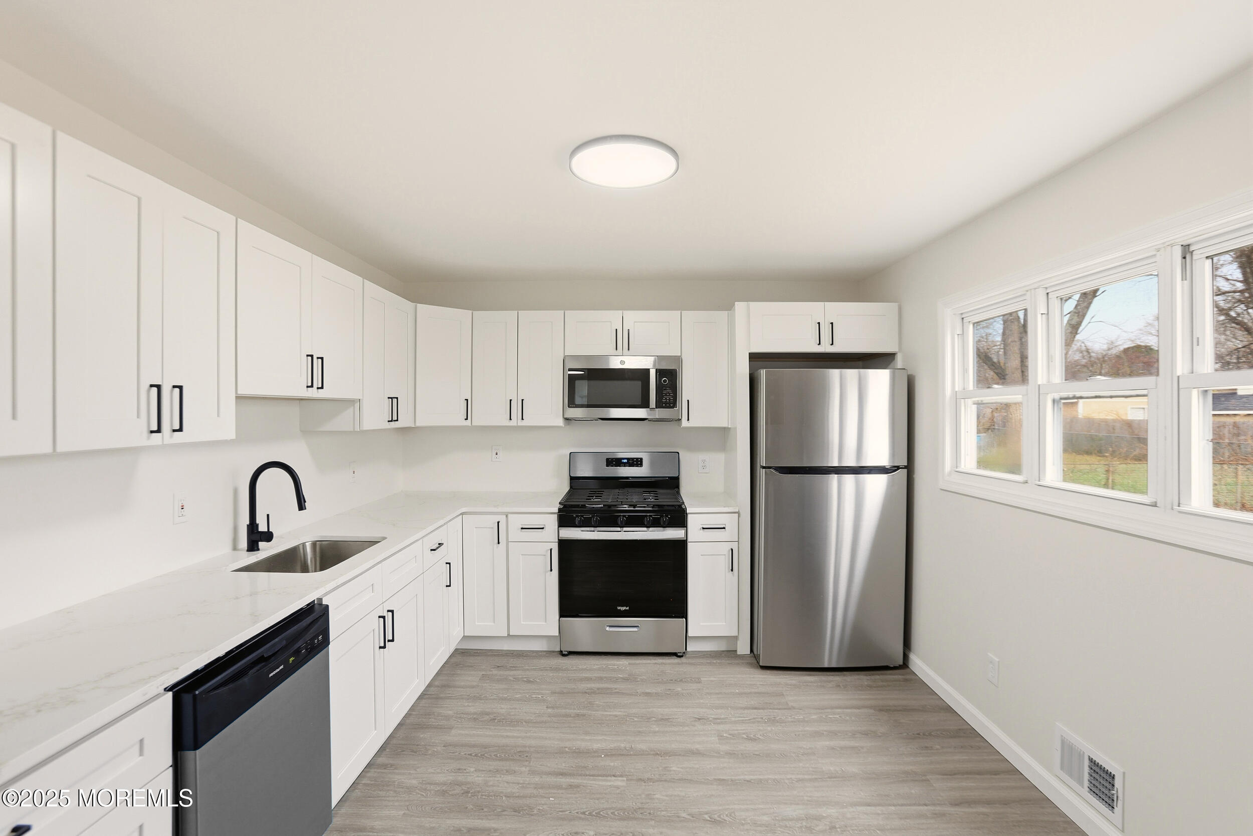 28 Brandies Road Toms River, NJ 08757 - Photo 12 of 30 a kitchen with a sink a refrigerator and cabinets