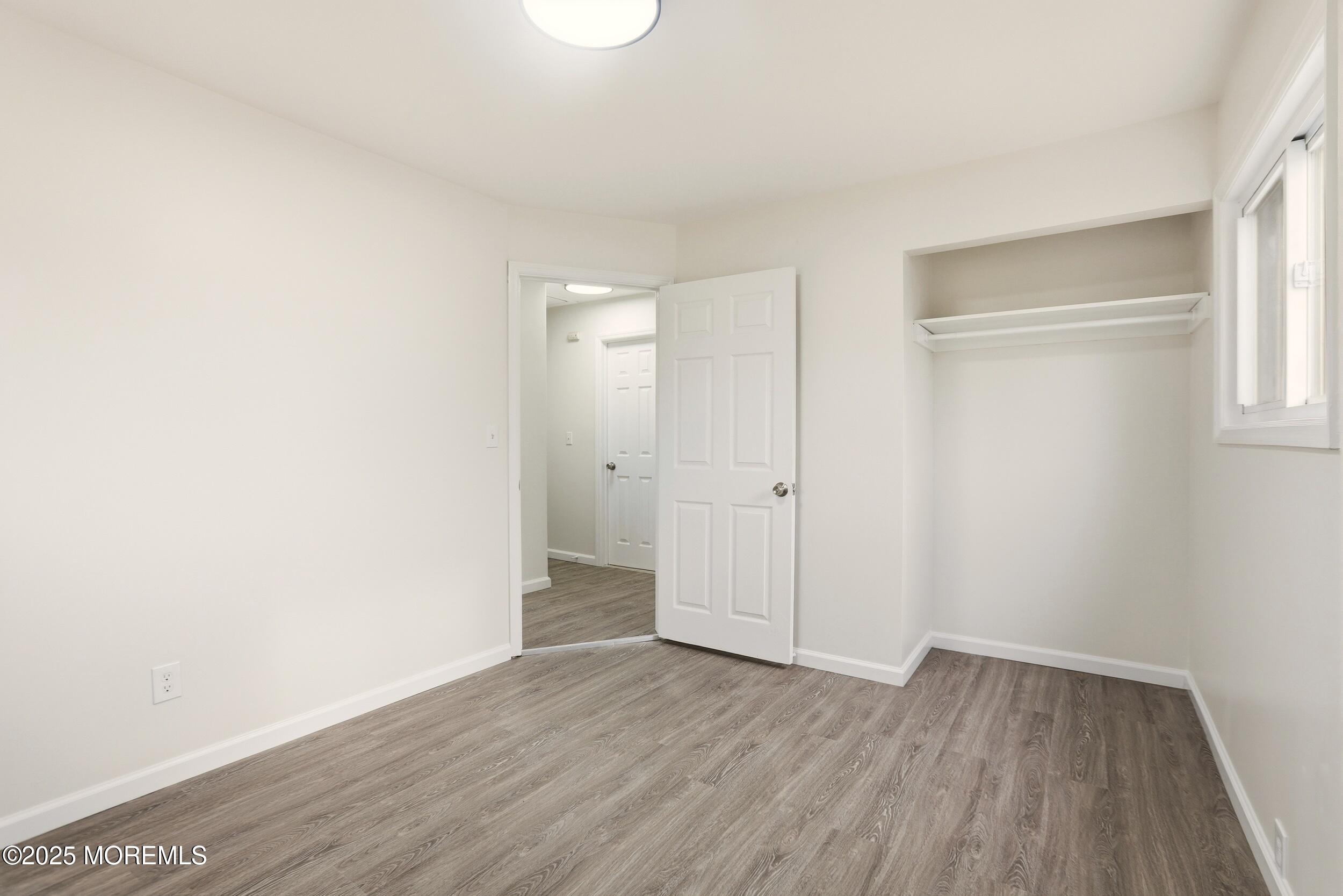 28 Brandies Road Toms River, NJ 08757 - Photo 18 of 30 a view of an empty room with wooden floor and a window