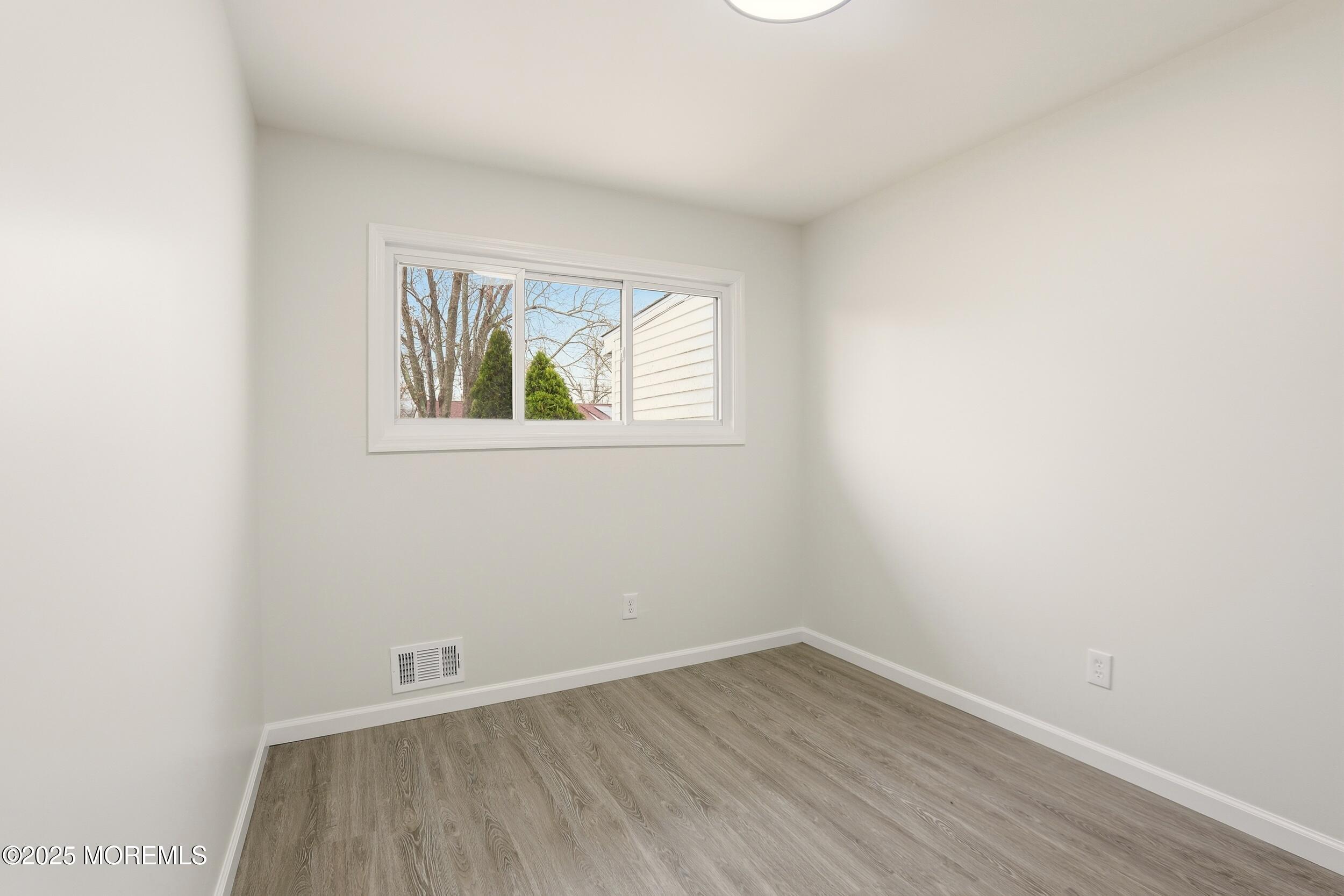 28 Brandies Road Toms River, NJ 08757 - Photo 19 of 30 an empty room with wooden floor and windows