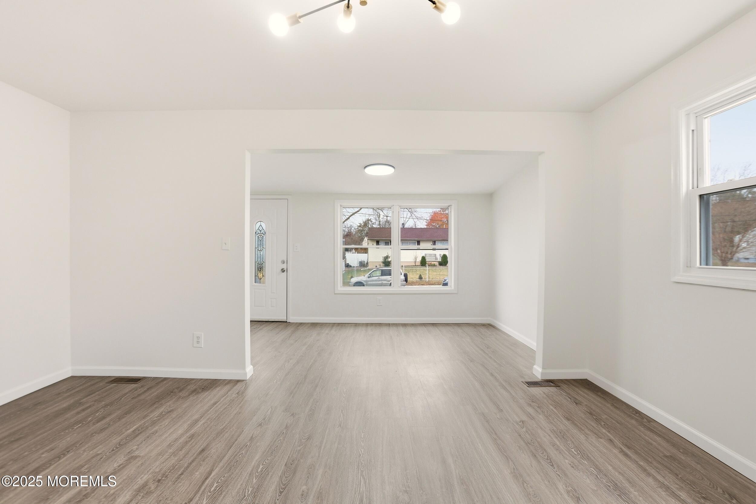 28 Brandies Road Toms River, NJ 08757 - Photo 8 of 30 an empty room with wooden floor and windows