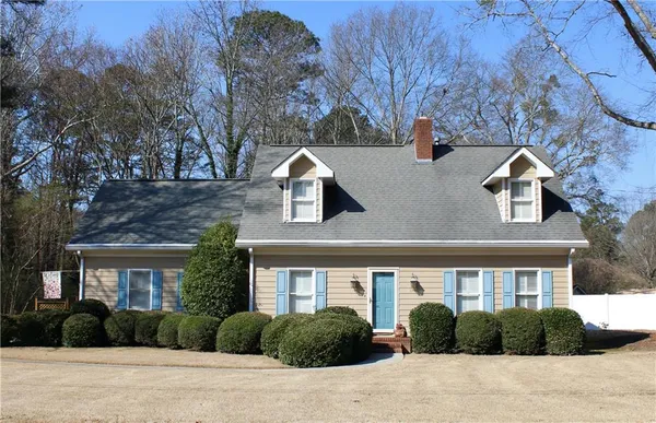 a front view of a house with garden and plants
