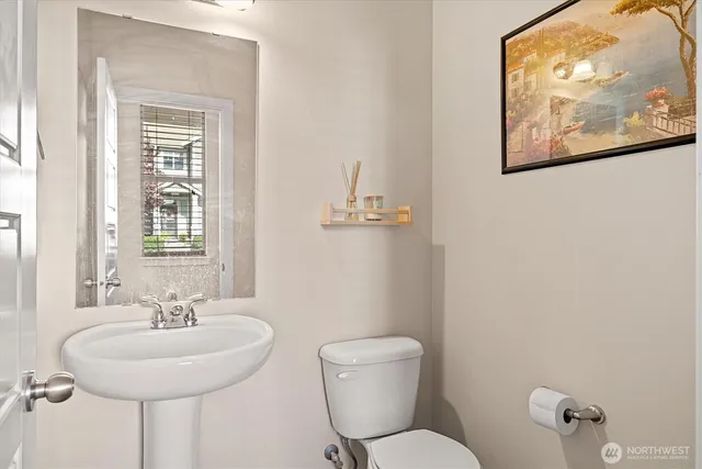 a bathroom with a toilet a sink and mirror