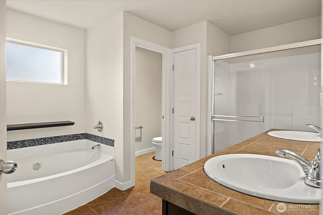 a bathroom with a granite countertop sink and a bathtub