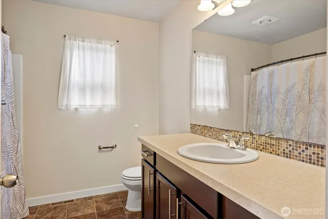 a bathroom with a sink toilet and mirror