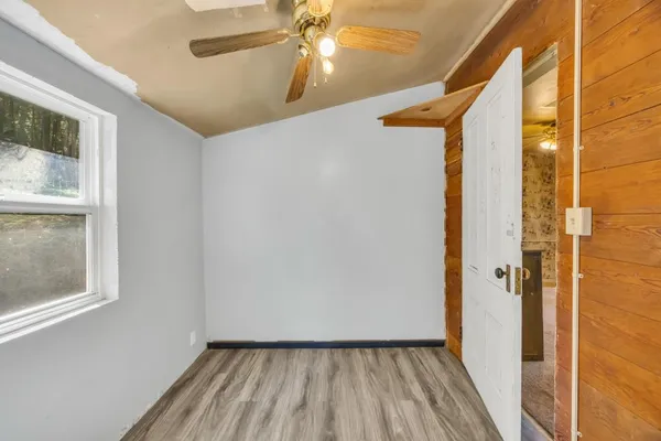 a view of a hallway with wooden floor and a window