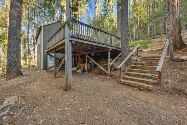 a view of a house with backyard and wooden fence