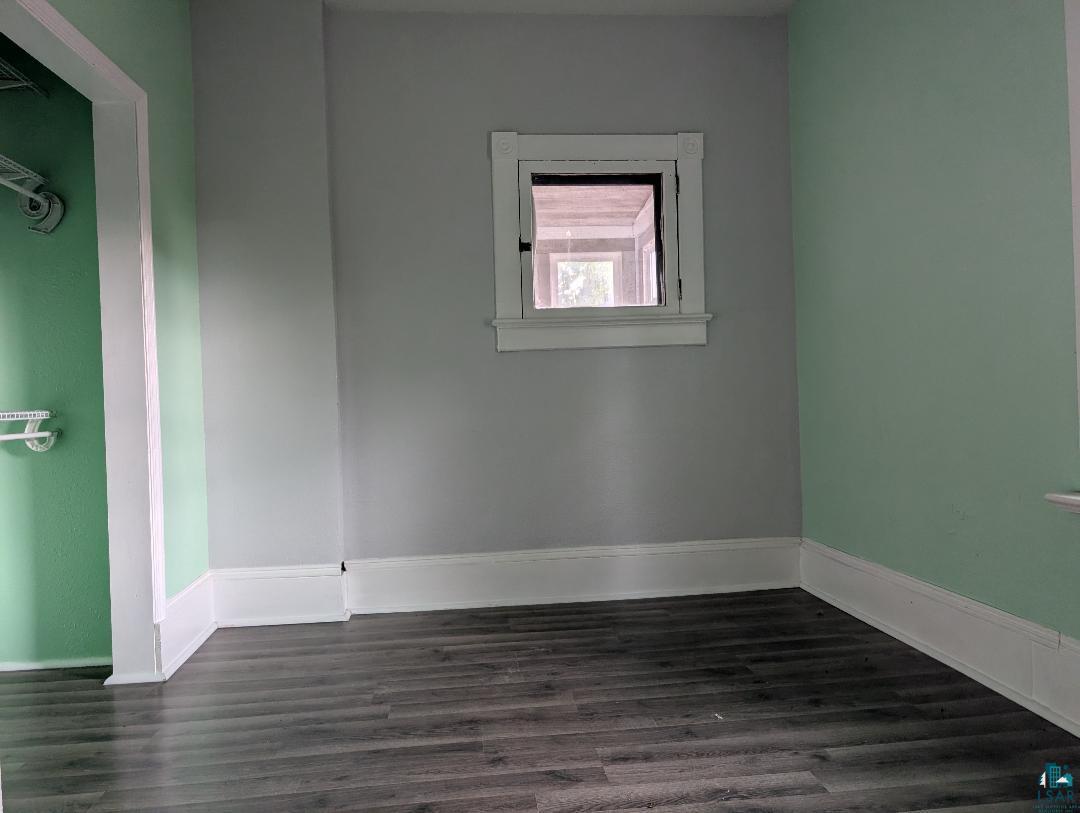 202 Thomas Street Mellen, WI 54546 - Photo 25 of 37 Wood-finish flooring with white trim, a single window, and a closet with built-in shelving