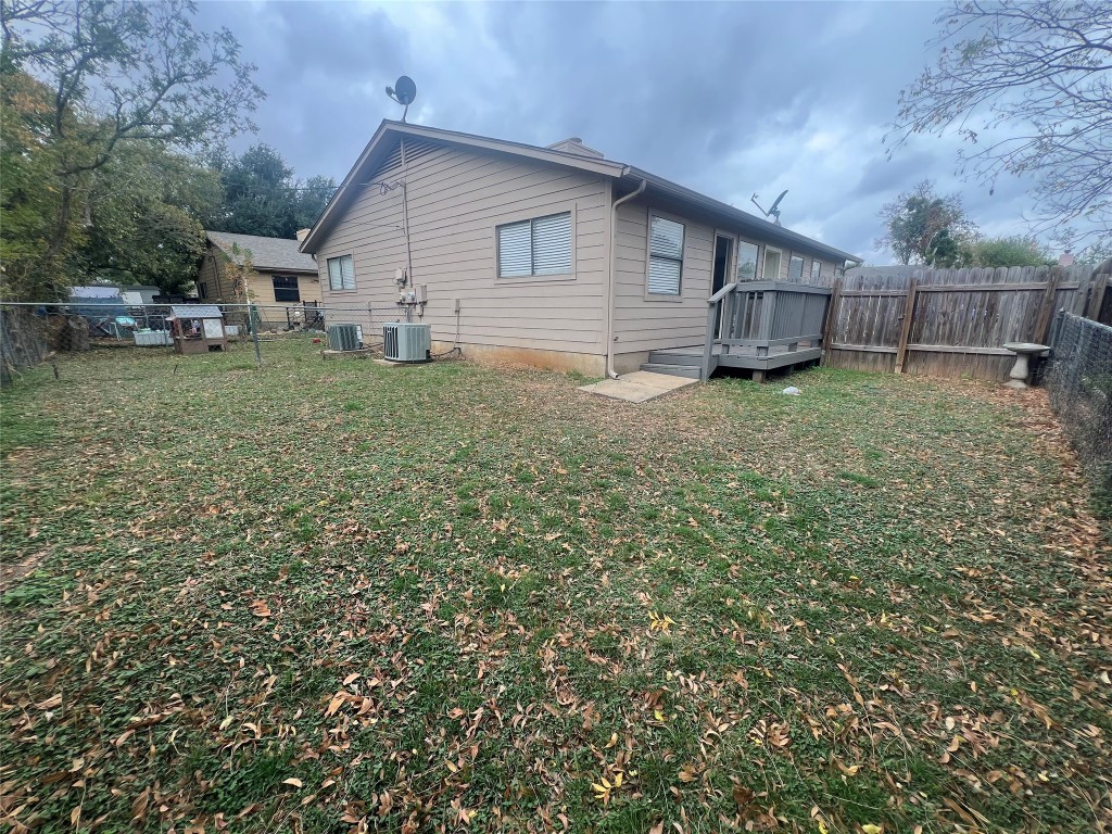 807 Lloyd Lane, Unit A Elgin, TX 78621 - Photo 14 of 16 Rear view of house with a fenced backyard and a deck