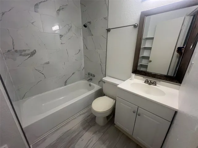 a bathroom with a sink toilet vanity and bathtub