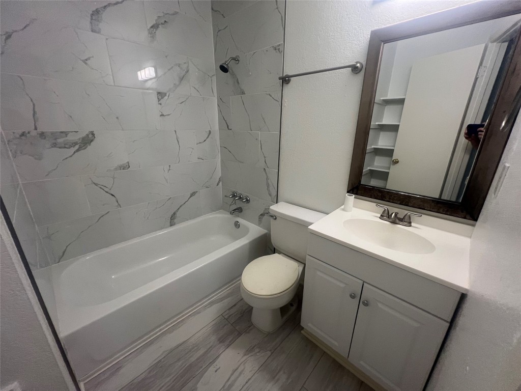 807 Lloyd Lane, Unit A Elgin, TX 78621 - Photo 2 of 16 Full bathroom featuring shower combination, vanity, and a textured wall