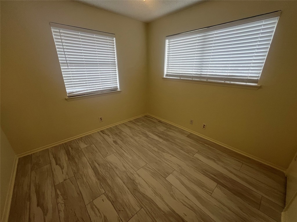 807 Lloyd Lane, Unit A Elgin, TX 78621 - Photo 3 of 16 Empty room with light wood finished floors and a textured ceiling