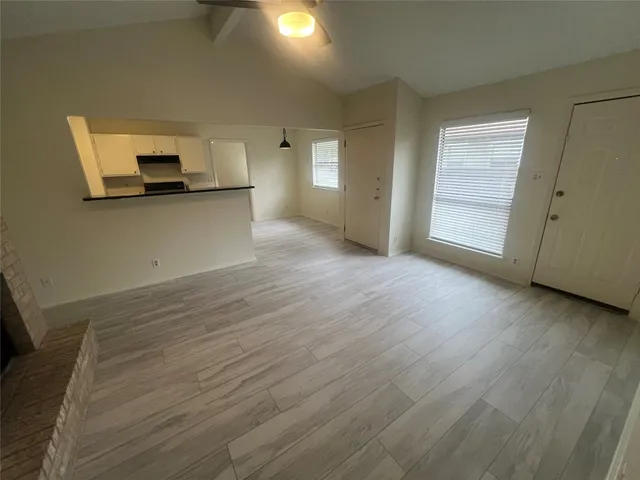 a view of a kitchen with wooden floor and a ceiling fan