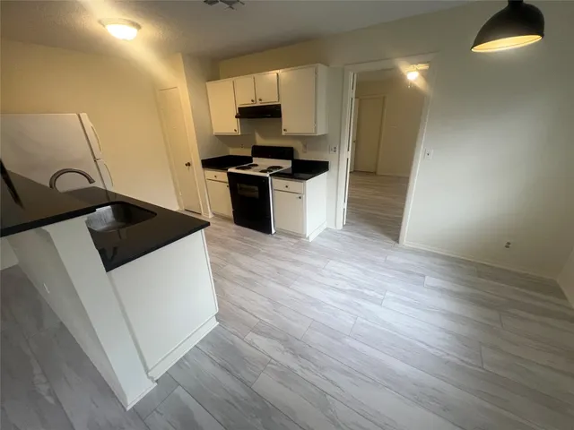 a kitchen with granite countertop a sink and a stove top oven