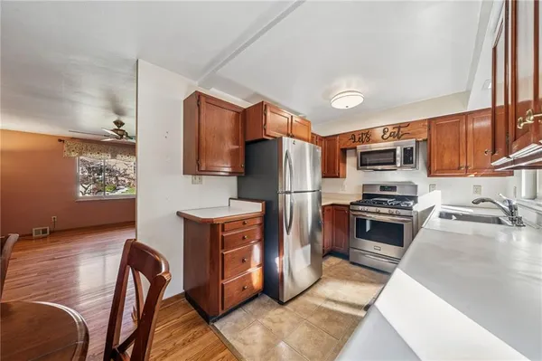 a kitchen with stainless steel appliances granite countertop a refrigerator stove microwave and sink