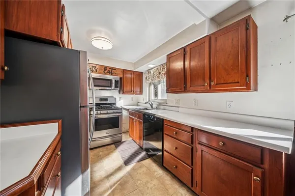 a kitchen with stainless steel appliances granite countertop wooden cabinets a stove top oven a sink and dishwasher