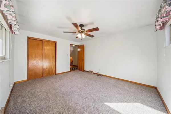 an empty room with closet and ceiling fan