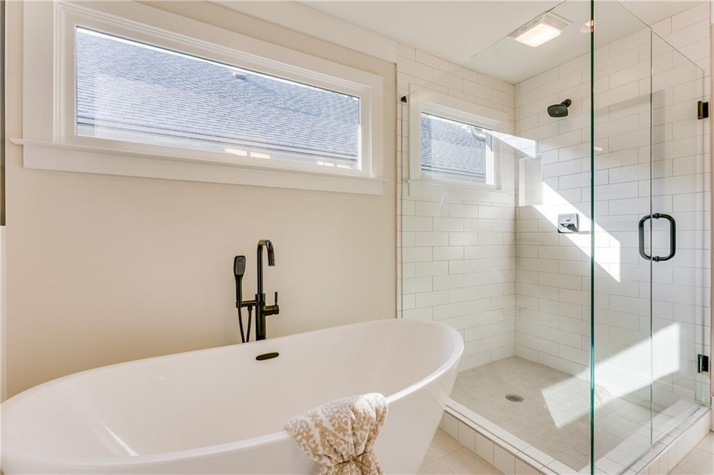 76 Mayson Avenue Northeast, Unit B Atlanta, GA 30307 - Photo 20 of 40 a bathroom with a white bath tub sitting next to shower