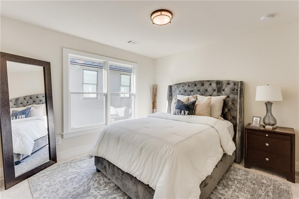76 Mayson Avenue Northeast, Unit B Atlanta, GA 30307 - Photo 23 of 40 a bedroom with a bed and a mirror