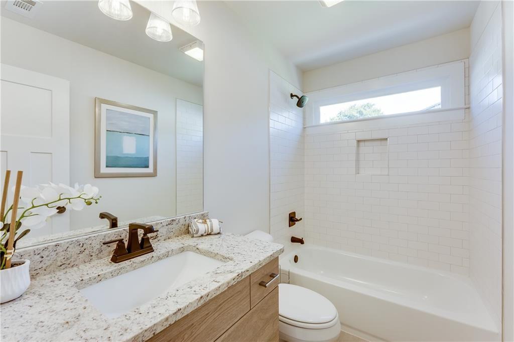 76 Mayson Avenue Northeast, Unit B Atlanta, GA 30307 - Photo 27 of 40 a bathroom with a granite countertop sink a toilet and bathtub