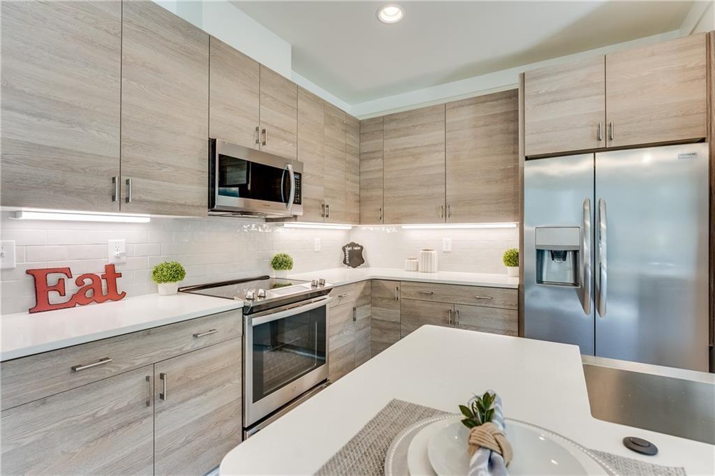 76 Mayson Avenue Northeast, Unit B Atlanta, GA 30307 - Photo 9 of 40 a kitchen with stainless steel appliances a white refrigerator a stove a sink and a microwave