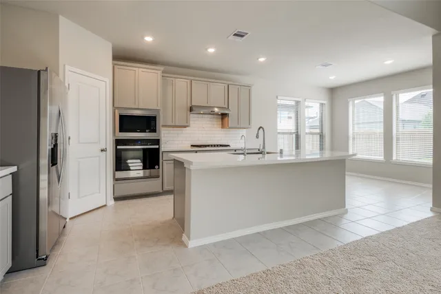 a kitchen with stainless steel appliances granite countertop a refrigerator sink and cabinets