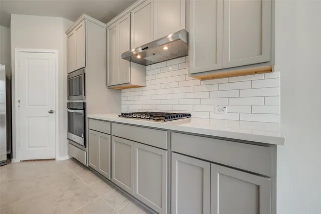 a kitchen with stainless steel appliances white cabinets and a refrigerator